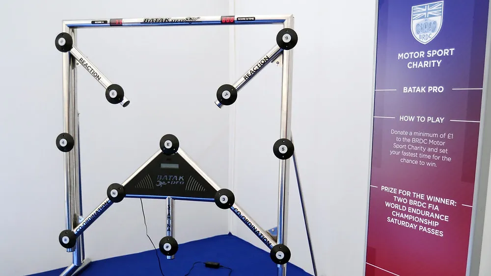 Batak Pro reaction board set up on an event stand beside a banner