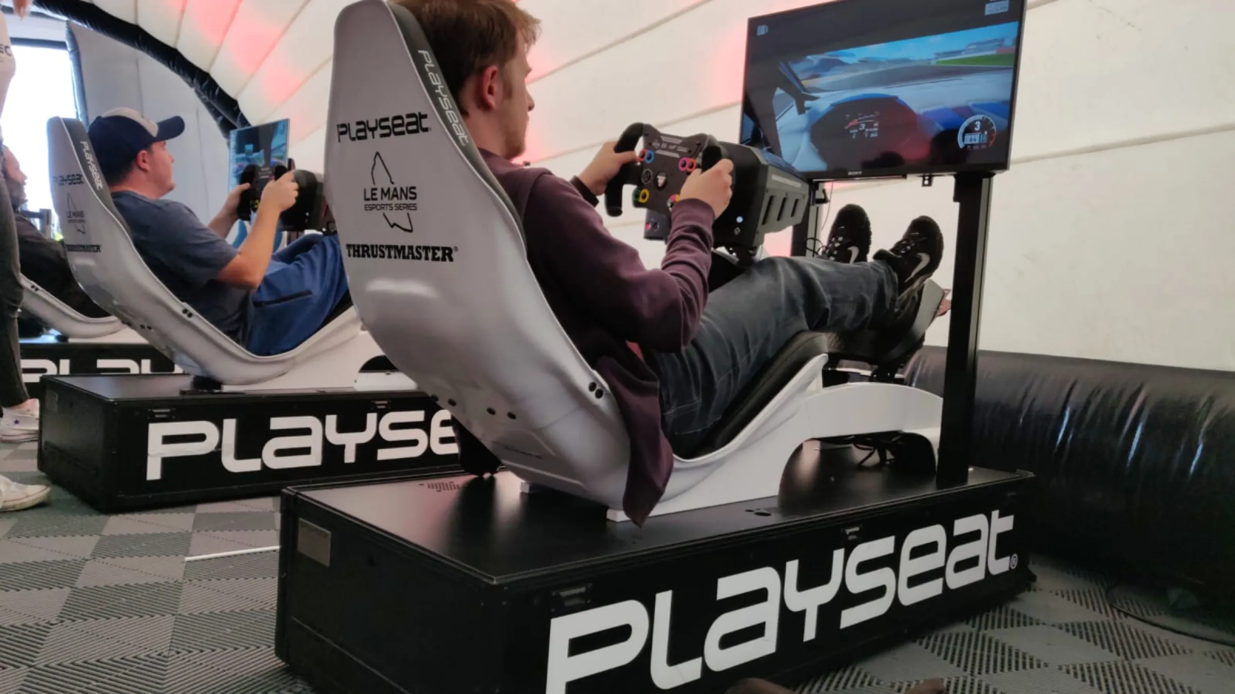 Guest playing on a racing simulator in an event marquee