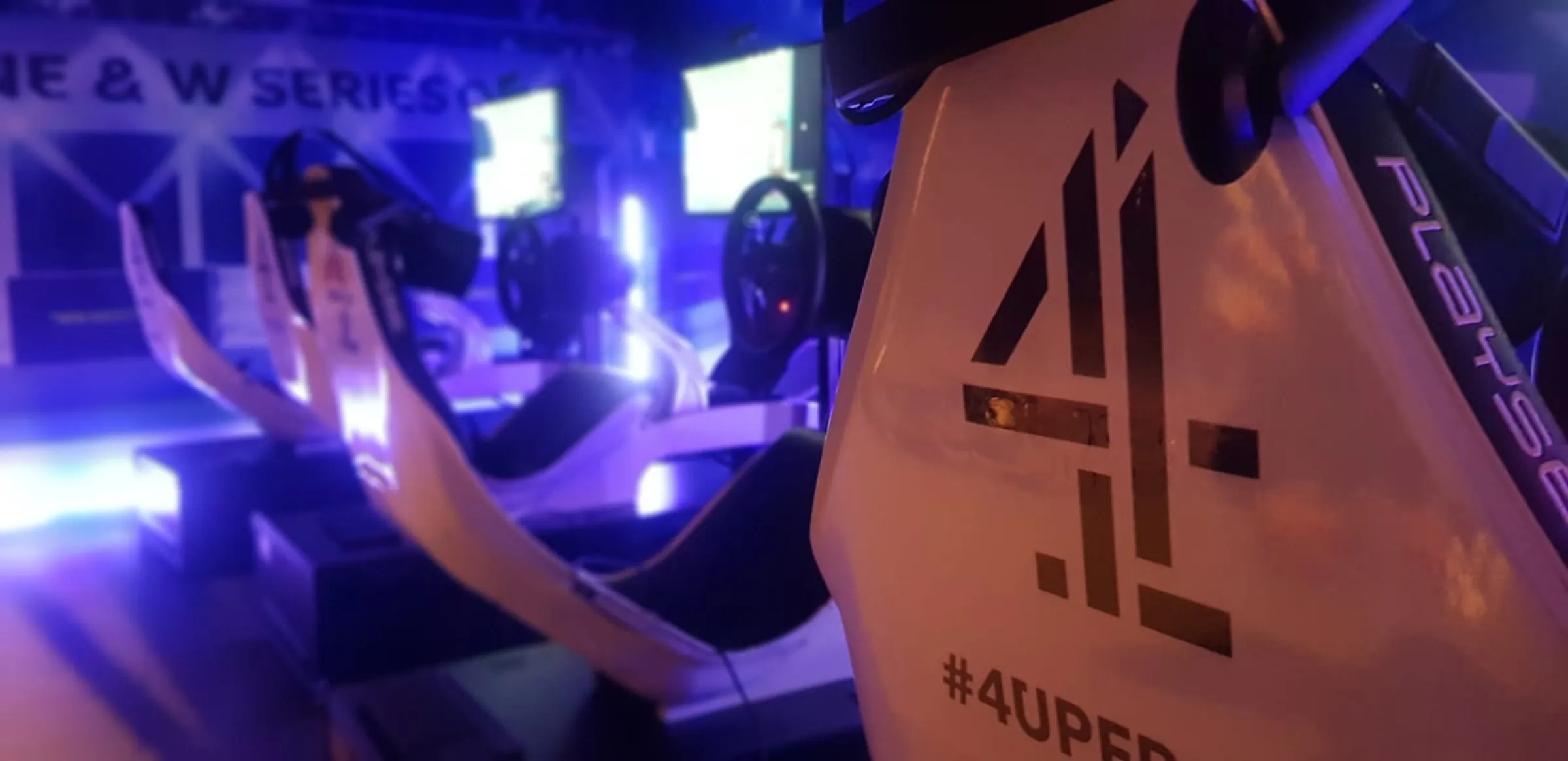 Guest racing a branded full-size F1 simulator at an evening event
