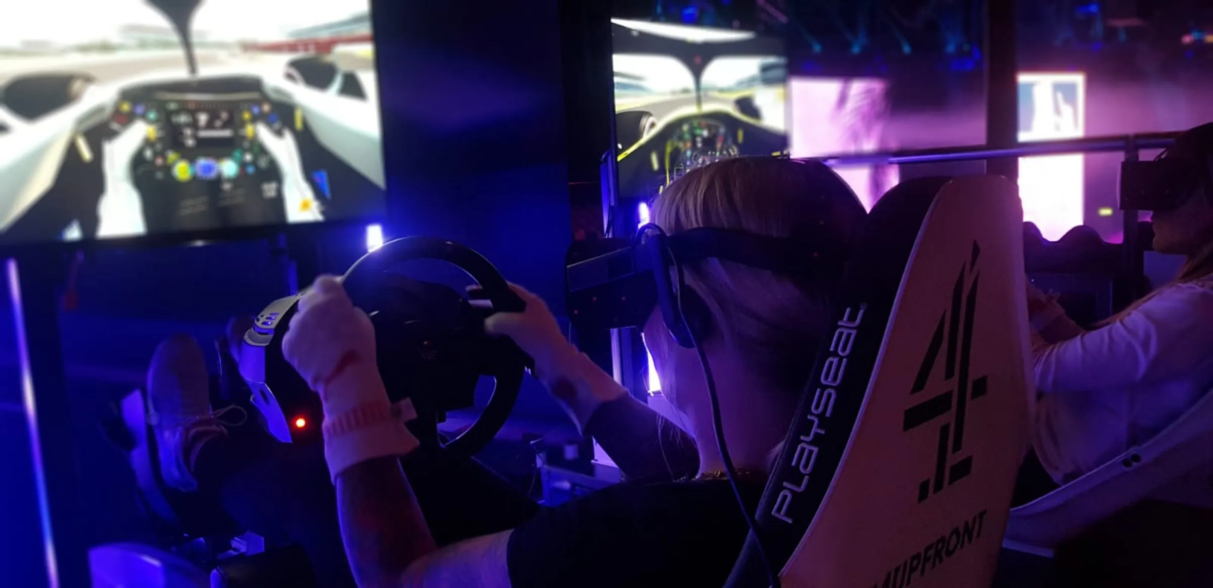 Guests racing full-size F1 simulators at an evening event