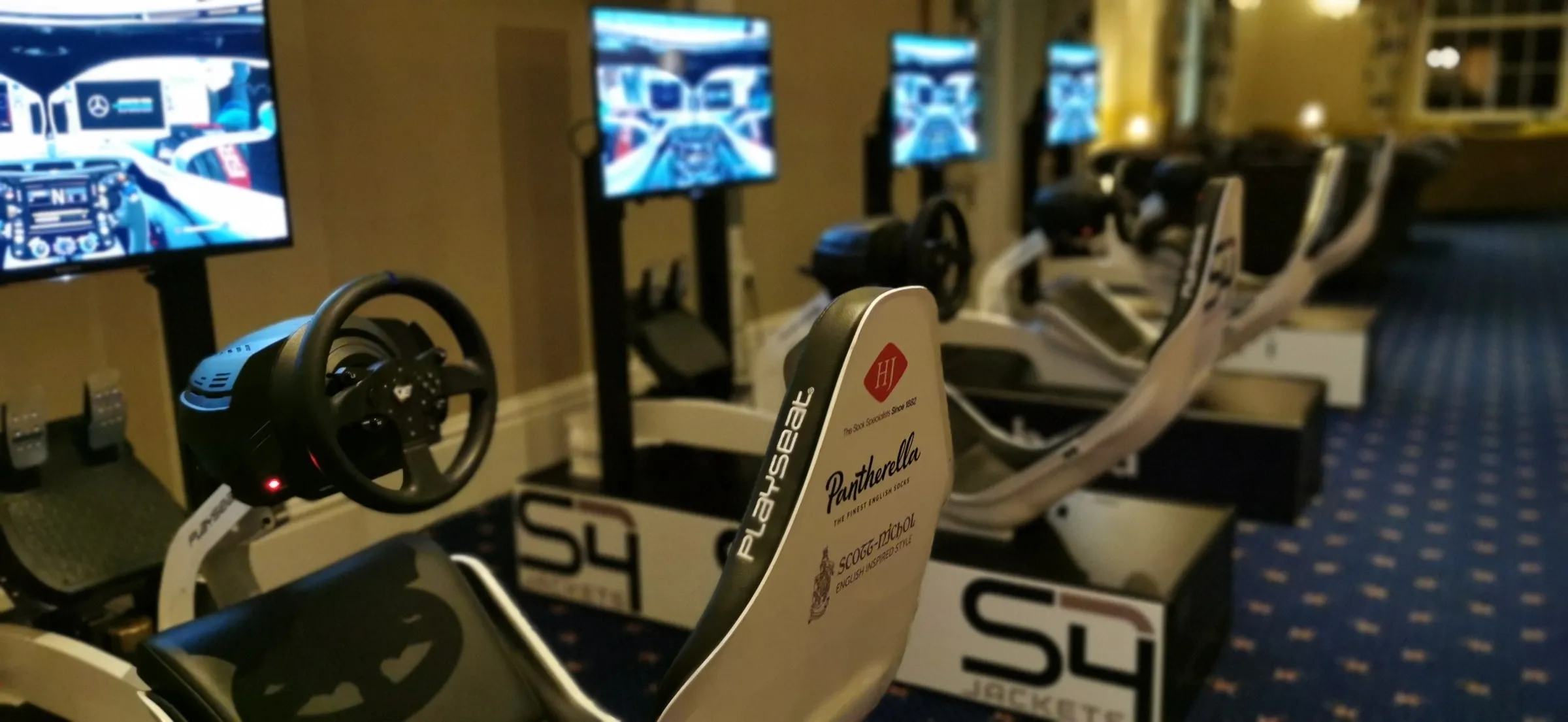 Row of white racing simulators set up in a hotel event space