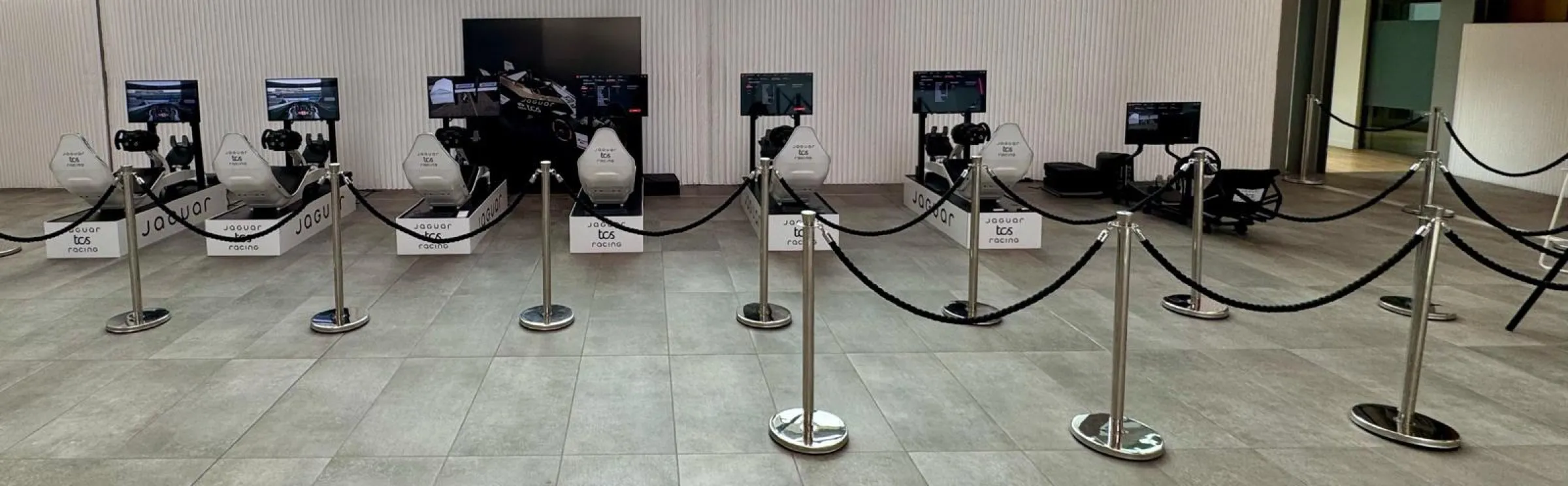 Six Jaguar TCS Racing branded simulators lined up in a row at an event