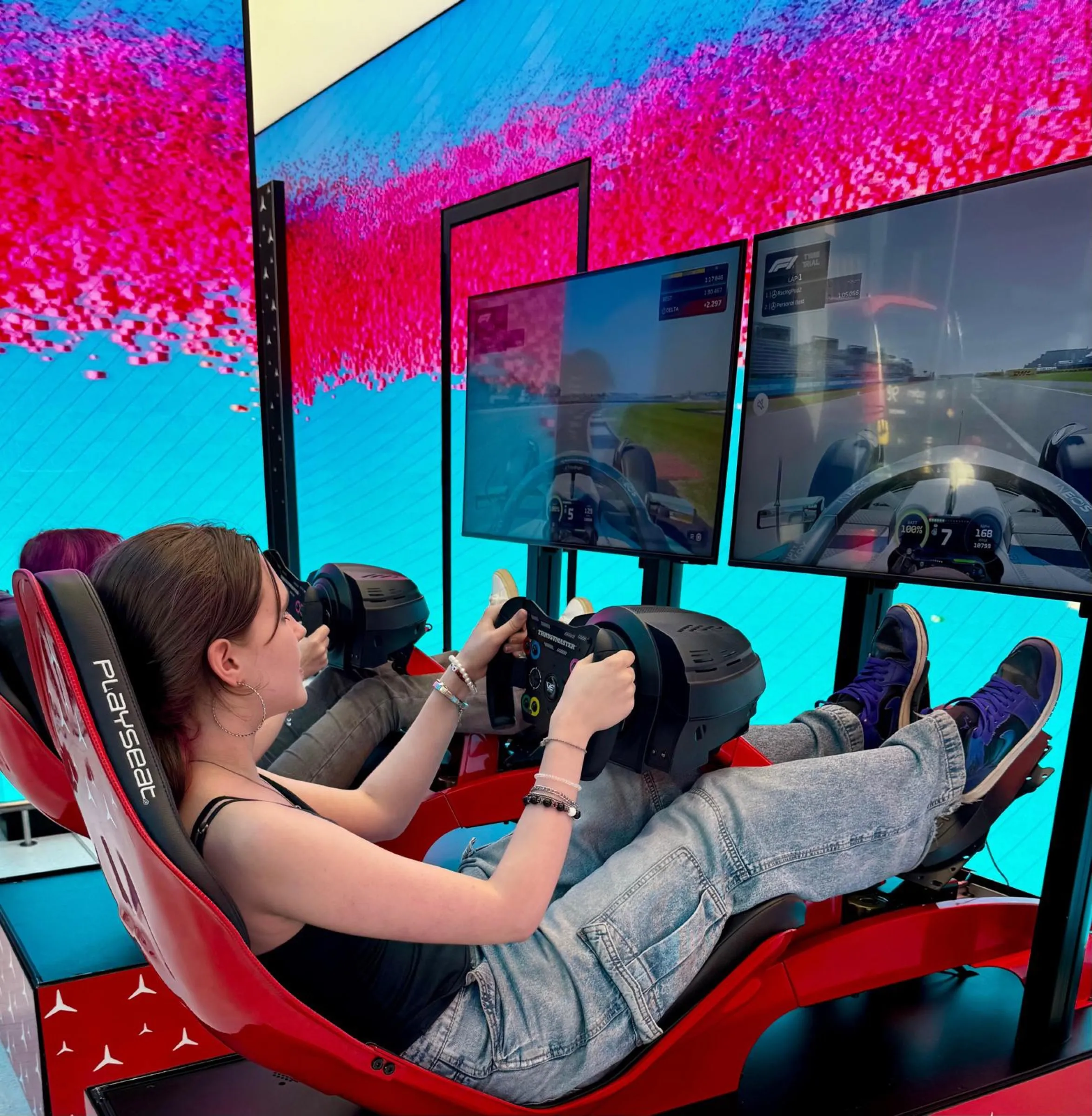 Guest racing a red simulator in front of a full LED wall at a corporate event
